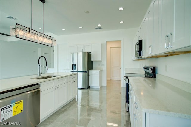 kitchen featuring appliances with stainless steel finishes, visible vents, a sink, and white cabinetry