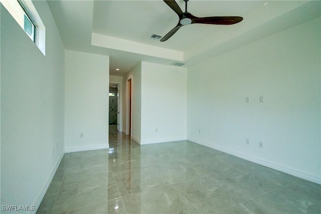 unfurnished room with a ceiling fan, visible vents, and baseboards