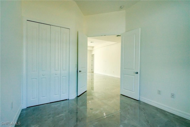 unfurnished bedroom with baseboards and a closet