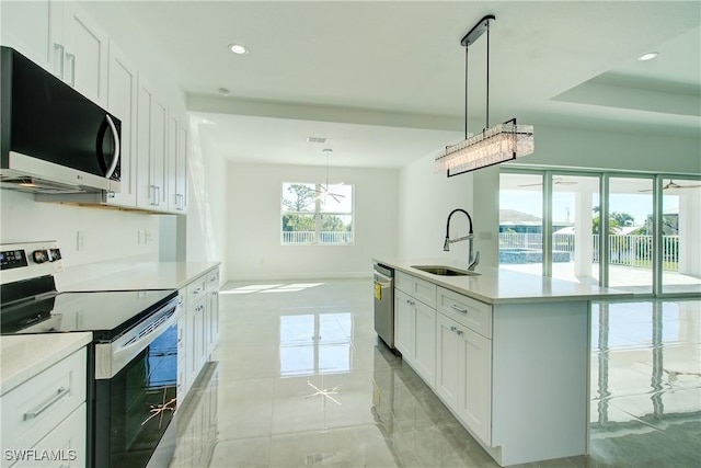 kitchen with recessed lighting, light countertops, appliances with stainless steel finishes, white cabinets, and a sink