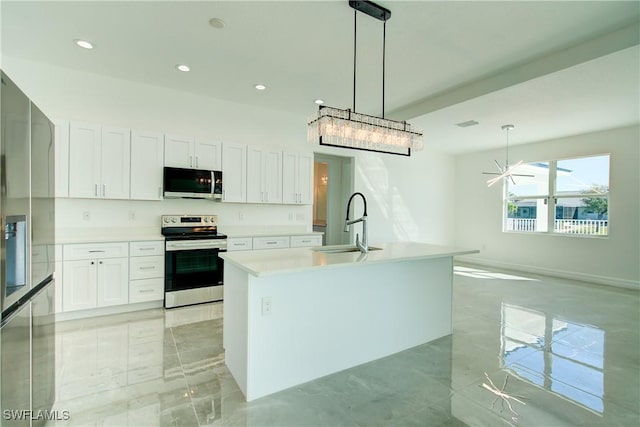 kitchen with stainless steel appliances, light countertops, a kitchen island with sink, a sink, and white cabinetry