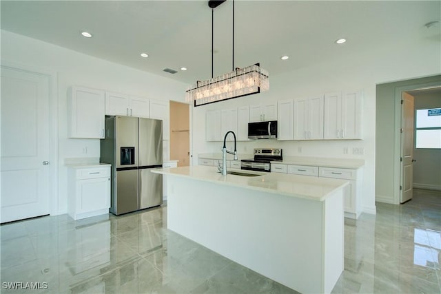 kitchen with appliances with stainless steel finishes, marble finish floor, white cabinets, and a sink