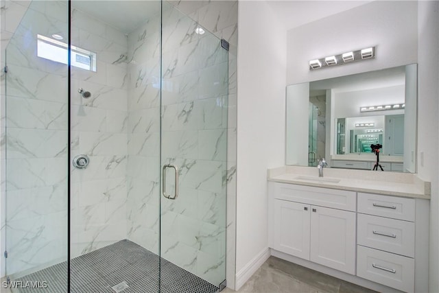 full bath featuring marble finish floor, baseboards, vanity, and a marble finish shower