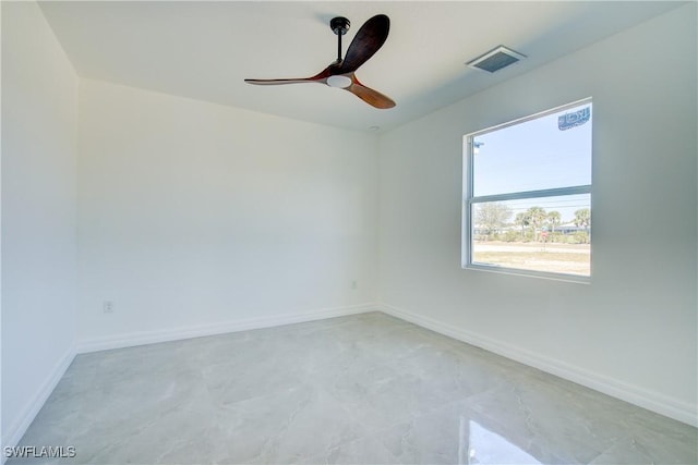 empty room featuring a ceiling fan, visible vents, and baseboards