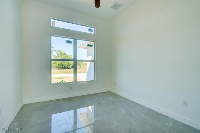 spare room with a ceiling fan, visible vents, and baseboards