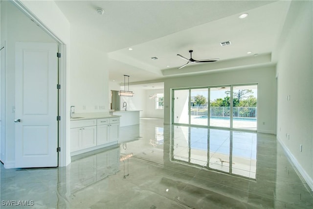 bathroom featuring a raised ceiling, a healthy amount of sunlight, visible vents, and marble finish floor