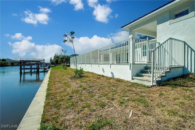 view of home's exterior featuring a water view and a boat dock