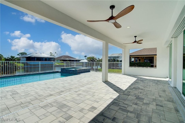 view of pool featuring a pool with connected hot tub, a patio area, ceiling fan, and fence