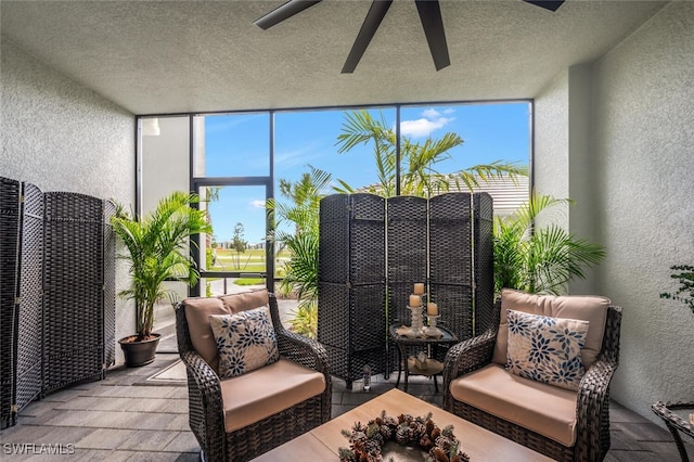 sunroom / solarium featuring a ceiling fan