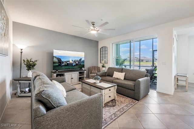 living room featuring light tile patterned floors, baseboards, and a ceiling fan