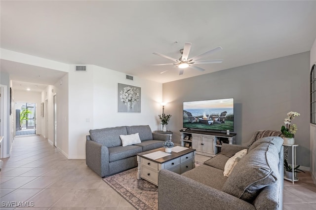 living area featuring light tile patterned flooring, visible vents, and ceiling fan