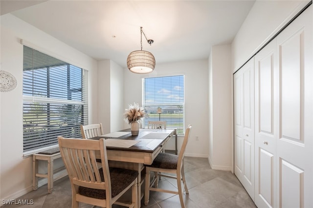 dining space with light tile patterned floors and baseboards