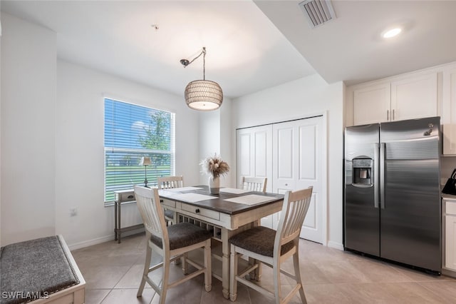 dining area with light tile patterned floors, visible vents, and baseboards