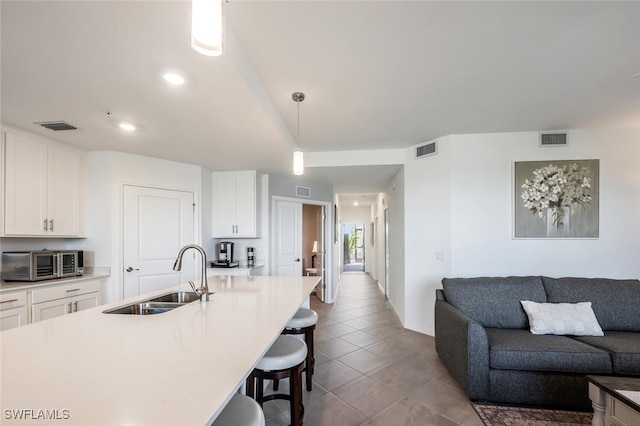 kitchen featuring a breakfast bar, visible vents, and a sink