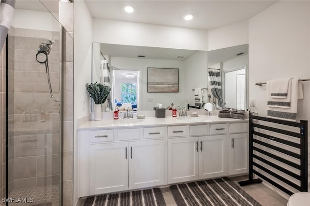 full bath with tile patterned floors, visible vents, vanity, and a tile shower