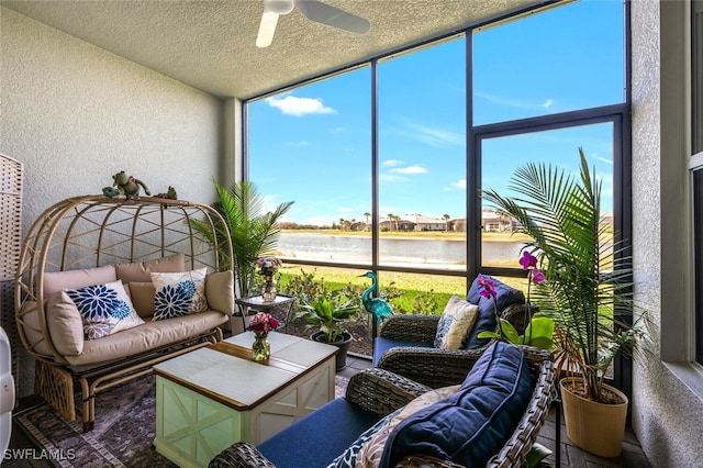 sunroom / solarium with a water view and ceiling fan