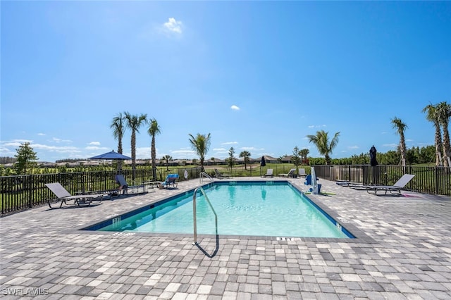 community pool with a patio and fence