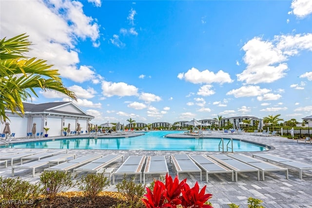 community pool with a patio area and fence