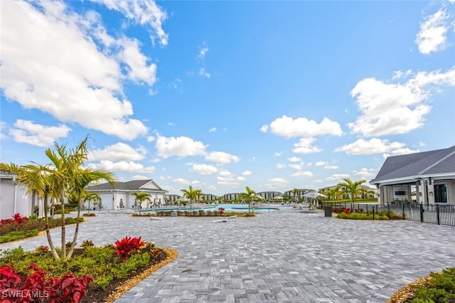 view of community with a swimming pool, a residential view, and fence