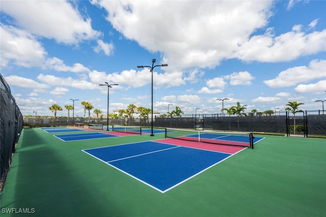 view of tennis court with community basketball court and fence