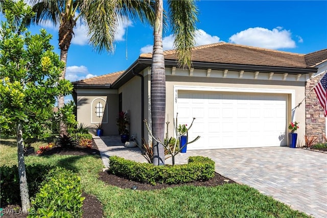 view of front facade with decorative driveway, an attached garage, and stucco siding