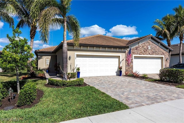 view of front of property featuring a garage, stone siding, decorative driveway, a front yard, and stucco siding