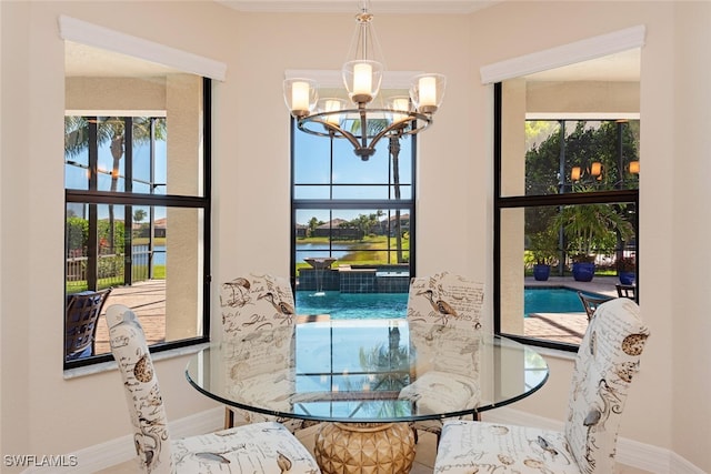 dining area featuring baseboards, an inviting chandelier, and a healthy amount of sunlight