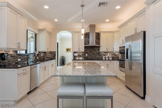 kitchen with light tile patterned floors, visible vents, appliances with stainless steel finishes, and wall chimney range hood