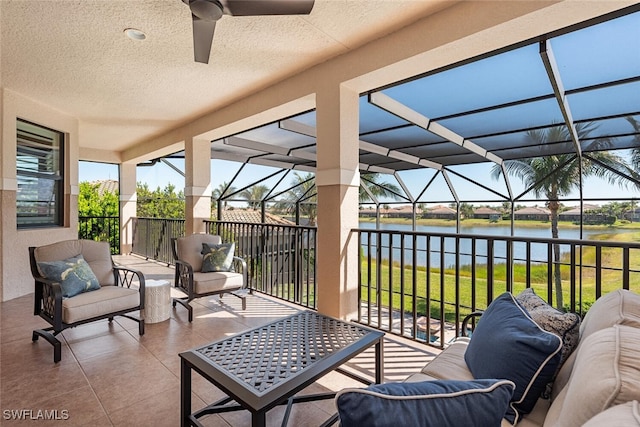 sunroom with a water view and ceiling fan