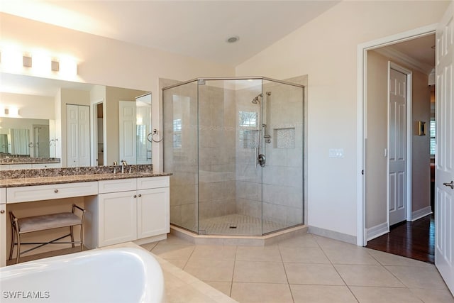 full bathroom with tile patterned floors, a stall shower, vanity, and vaulted ceiling