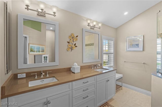 bathroom featuring lofted ceiling, double vanity, baseboards, and a sink