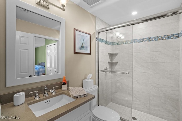 ensuite bathroom featuring vanity, visible vents, a shower stall, ensuite bathroom, and toilet