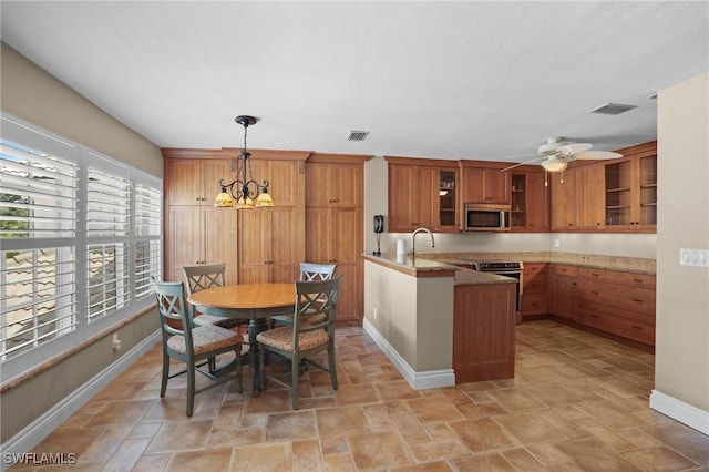 kitchen with a peninsula, visible vents, brown cabinets, and stainless steel appliances