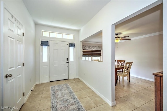 entrance foyer featuring light tile patterned floors, crown molding, a ceiling fan, and baseboards