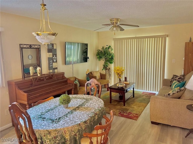 dining room featuring ceiling fan, wood finished floors, and a textured ceiling