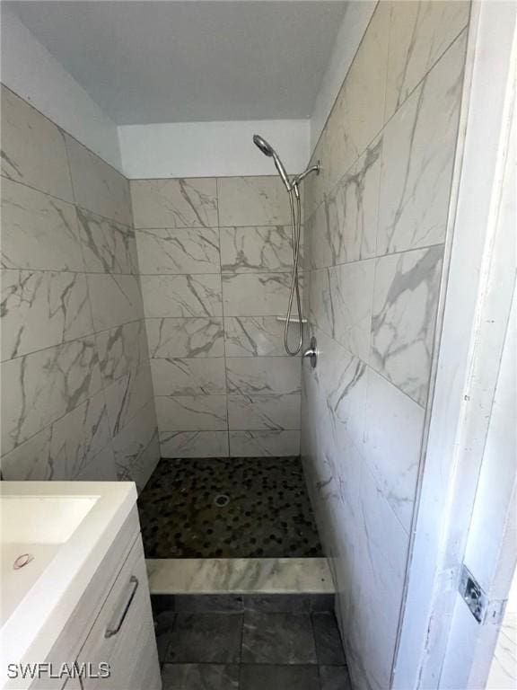 bathroom featuring a tile shower and vanity