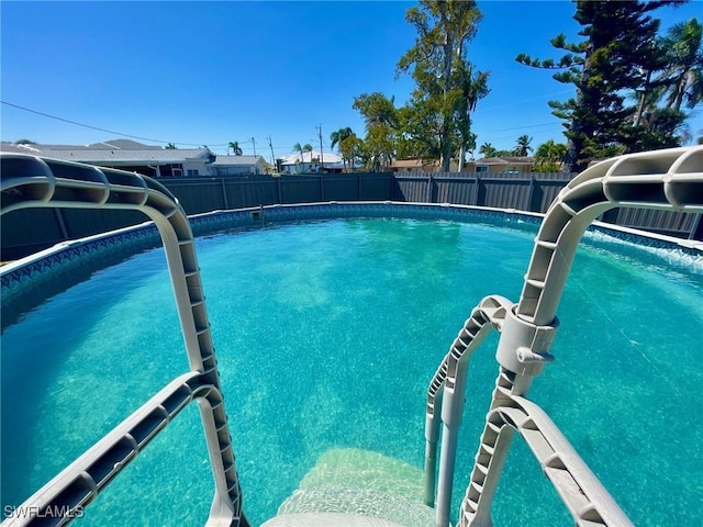 view of swimming pool with a fenced backyard and a fenced in pool