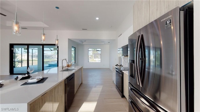 kitchen with dishwashing machine, a sink, stainless steel refrigerator with ice dispenser, black electric range oven, and modern cabinets