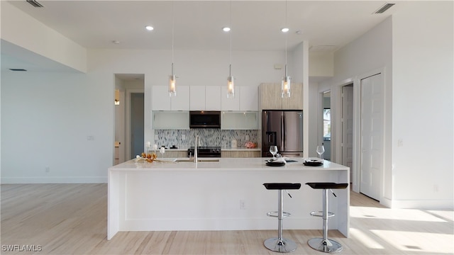 kitchen featuring stainless steel appliances, a sink, visible vents, light countertops, and modern cabinets