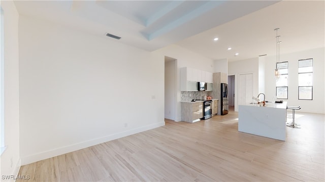 kitchen with visible vents, decorative backsplash, modern cabinets, stainless steel appliances, and light countertops