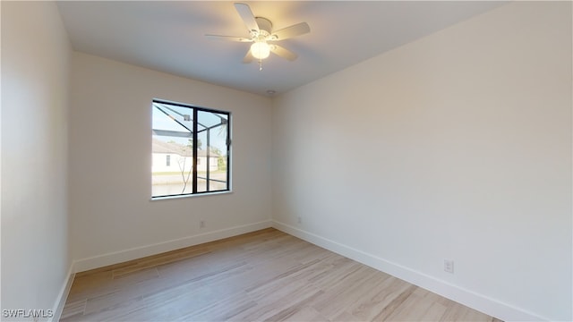 empty room featuring ceiling fan, light wood-style flooring, and baseboards