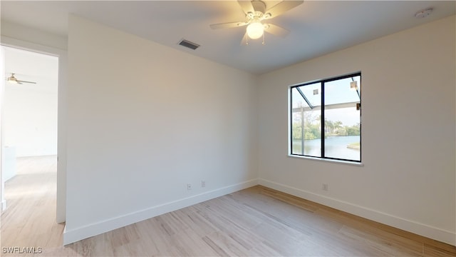 unfurnished room featuring light wood-style flooring, visible vents, ceiling fan, and baseboards