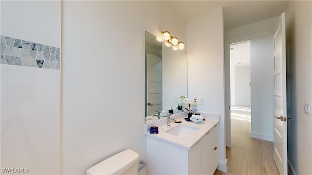 bathroom with vanity, toilet, and wood finished floors