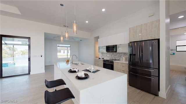 kitchen featuring decorative backsplash, light countertops, black appliances, and modern cabinets