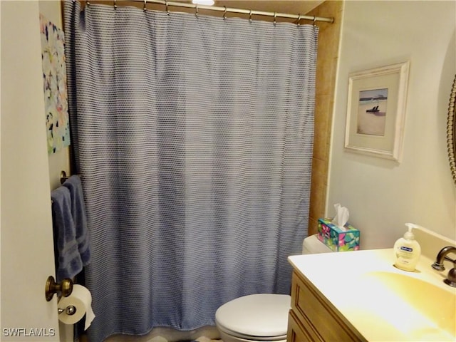 bathroom featuring toilet, a shower with shower curtain, and vanity