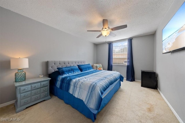 carpeted bedroom featuring a ceiling fan, baseboards, and a textured ceiling