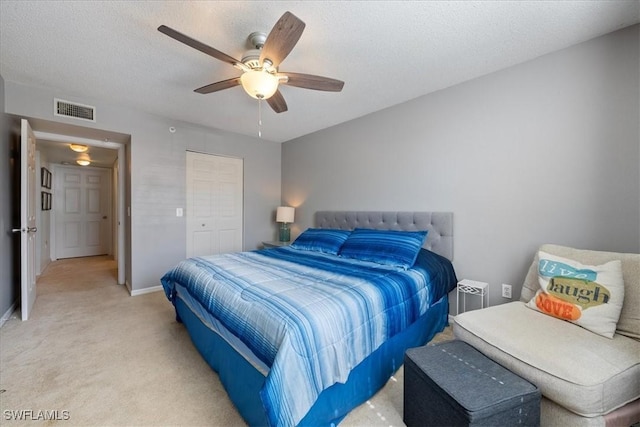 bedroom with visible vents, light carpet, a textured ceiling, baseboards, and ceiling fan