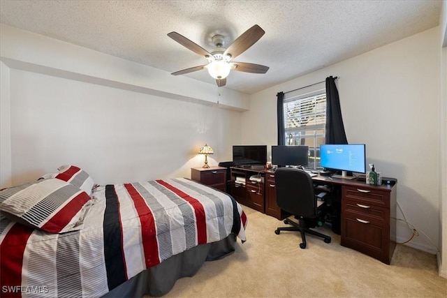 bedroom with a ceiling fan, light colored carpet, and a textured ceiling