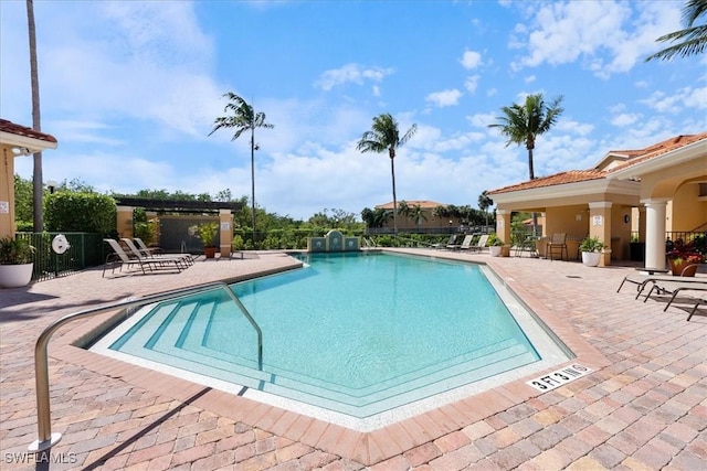 pool with a patio and fence