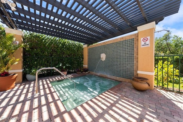 view of patio / terrace featuring a hot tub and fence